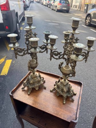 Pair of tall five-branch brass candelabra on a tray-top table