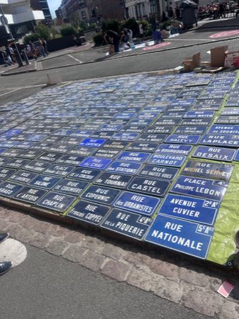 Dozens of genuine vintage French enamel street-name signs laid out for sale