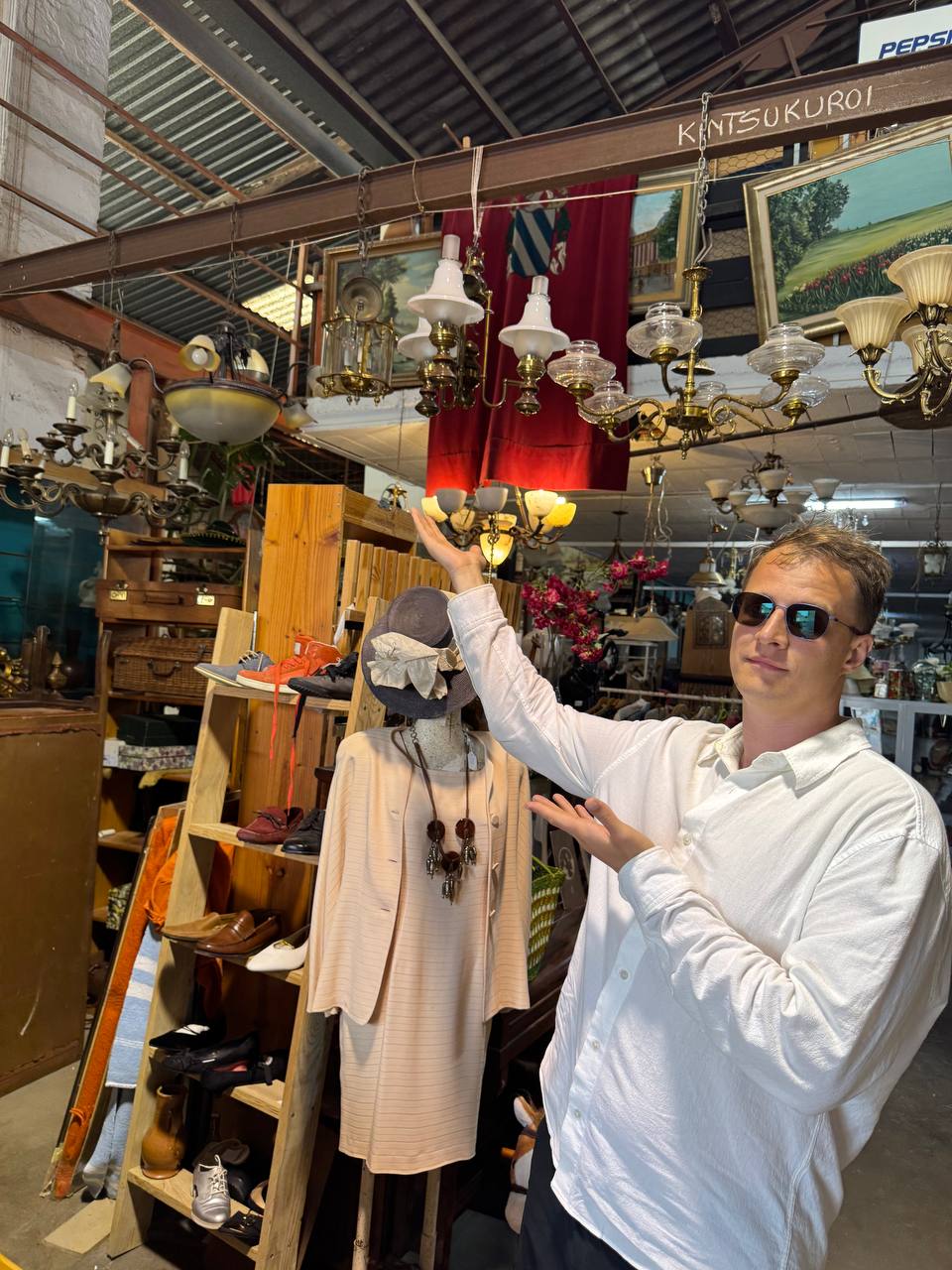 Oleksandr Prudnikov in a UK vintage shop showing vintage lamps — UK reseller experience