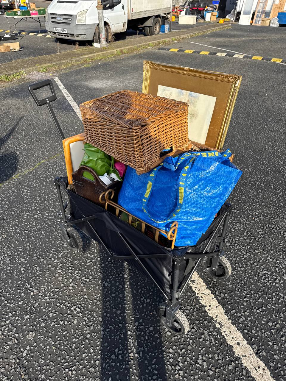 Wheel cart loaded with a UK car boot haul of vintage items