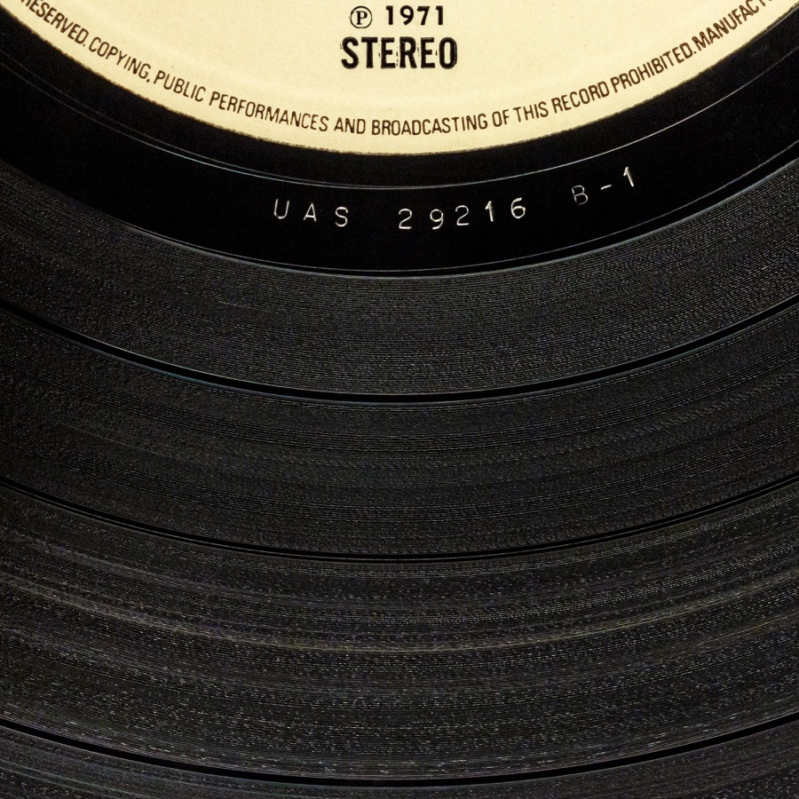 A vinyl record's label and the surrounding runout groove area, where the matrix number etching is visible